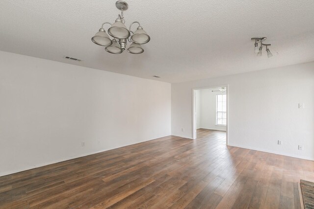 920 Turtle Cv Unit 252, Irving, TX 75060 - spare room featuring a chandelier, dark wood-type flooring, and a textured ceiling