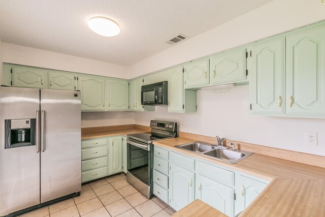 920 Turtle Cv Unit 252, Irving, TX 75060 - kitchen featuring stainless steel appliances, a sink, light tile patterned flooring, light countertops, and a textured ceiling