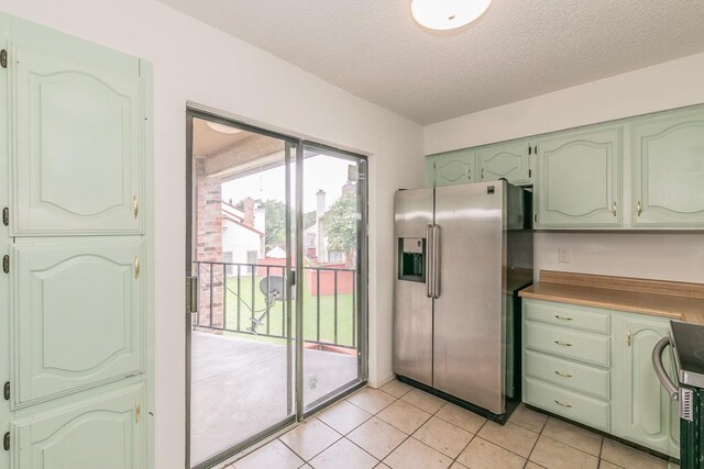 920 Turtle Cv Unit 252, Irving, TX 75060 - kitchen featuring stainless steel fridge with ice dispenser, green cabinets, range, light tile patterned floors, and a textured ceiling
