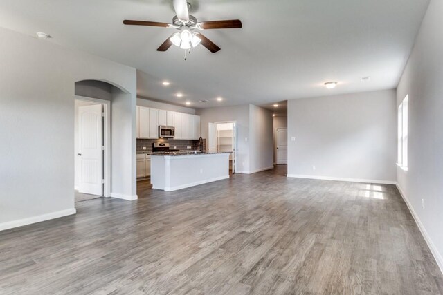 2089 Hartley Dr, Forney, TX 75126 - unfurnished living room with baseboards, a ceiling fan, wood finished floors, recessed lighting, and a sink