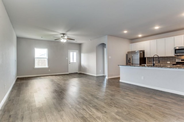 2089 Hartley Dr, Forney, TX 75126 - kitchen featuring appliances with stainless steel finishes, dark stone counters, white cabinetry, backsplash, and ceiling fan