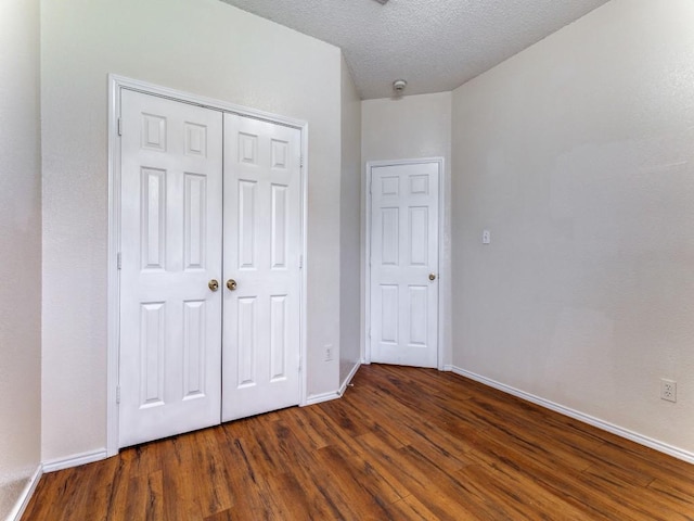 7116 Park Creek Cir E, Fort Worth, TX 76137 - unfurnished bedroom featuring wood finished floors, baseboards, a closet, and a textured ceiling