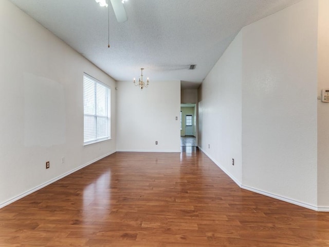 7116 Park Creek Cir E, Fort Worth, TX 76137 - spare room with a chandelier, wood finished floors, a ceiling fan, baseboards, and a textured ceiling
