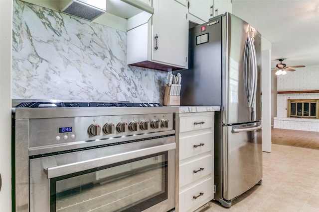 1816 Chattanooga, Bedford, TX 76021 - kitchen featuring appliances with stainless steel finishes, a ceiling fan, white cabinetry, a brick fireplace, and light countertops