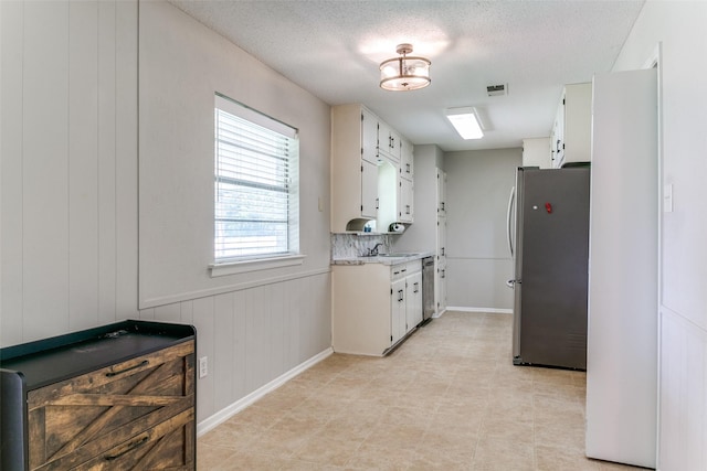 1816 Chattanooga, Bedford, TX 76021 - kitchen with appliances with stainless steel finishes, light countertops, white cabinets, a sink, and a textured ceiling