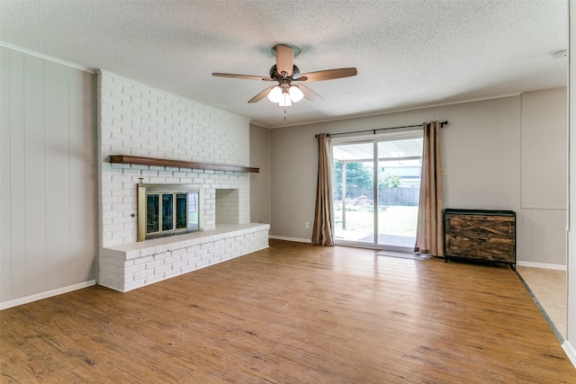 1816 Chattanooga, Bedford, TX 76021 - unfurnished living room with a textured ceiling, light wood-style flooring, a brick fireplace, ceiling fan, and ornamental molding