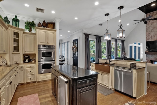 105 Esplanade Ct, Bossier City, LA 71111 - kitchen featuring appliances with stainless steel finishes, cream cabinets, a center island with sink, open floor plan, and recessed lighting
