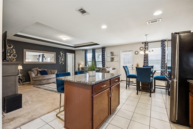2224 Heaton St, Forney, TX 75126 - kitchen featuring freestanding refrigerator, a kitchen breakfast bar, open floor plan, a raised ceiling, and recessed lighting