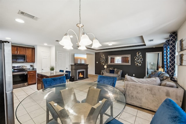 2224 Heaton St, Forney, TX 75126 - dining room with light tile patterned floors, a chandelier, a lit fireplace, recessed lighting, and a tray ceiling