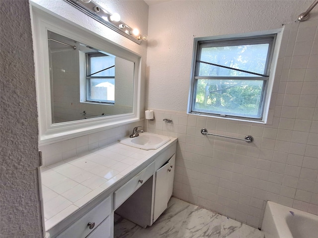 3717 W Spurgeon St, Fort Worth, TX 76133 - bathroom featuring vanity, marble finish floors, tile walls, and a textured wall