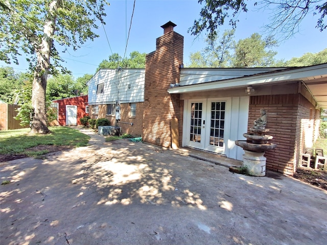 3717 W Spurgeon St, Fort Worth, TX 76133 - back of house featuring french doors, brick siding, a chimney, and a patio area
