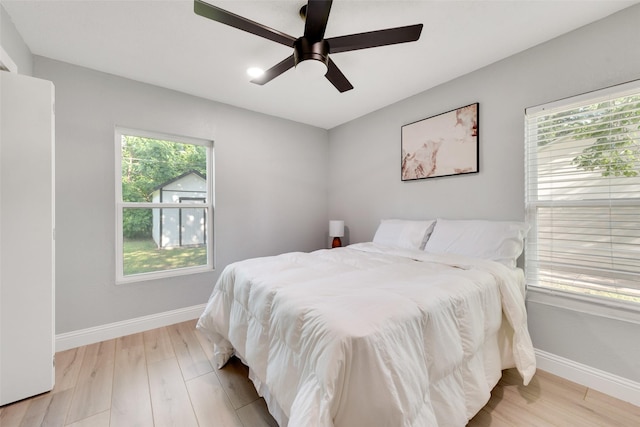 228 Harrison Ln, Hurst, TX 76053 - bedroom with light wood-style flooring, baseboards, and a ceiling fan