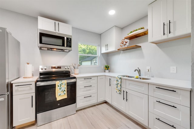 228 Harrison Ln, Hurst, TX 76053 - kitchen with appliances with stainless steel finishes, a sink, open shelves, white cabinetry, and light countertops