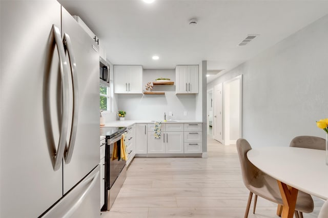 228 Harrison Ln, Hurst, TX 76053 - kitchen with stainless steel appliances, open shelves, a sink, light countertops, and white cabinets