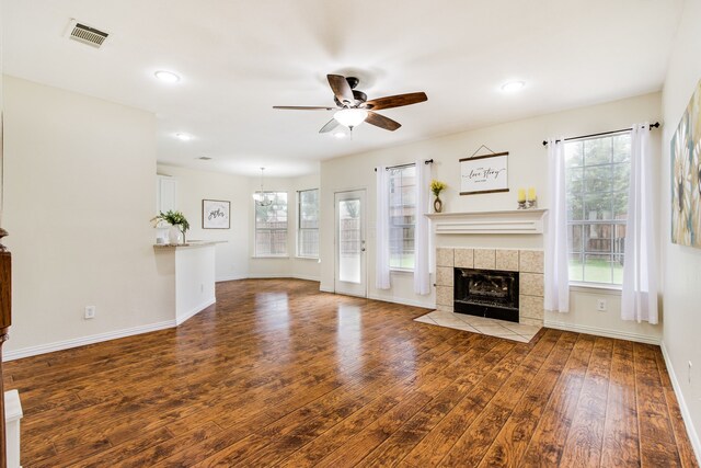 2001 Bosbury Dr, Flower Mound, TX 75028 - unfurnished living room with a ceiling fan, wood finished floors, a tile fireplace, stairway, and baseboards