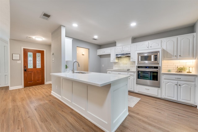 7581 Kings Ridge Rd, Frisco, TX 75035 - kitchen with appliances with stainless steel finishes, a sink, decorative backsplash, white cabinets, and a peninsula