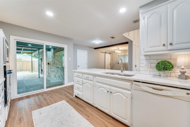 7581 Kings Ridge Rd, Frisco, TX 75035 - kitchen featuring dishwasher, a sink, light wood-type flooring, white cabinetry, and backsplash
