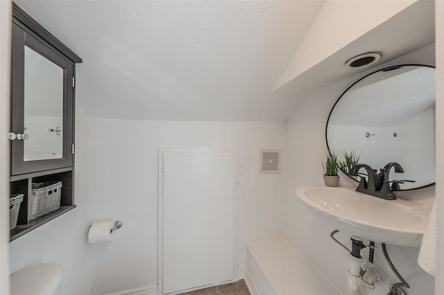 8726 San Fernando Way, Dallas, TX 75218 - bathroom featuring lofted ceiling, toilet, and a sink