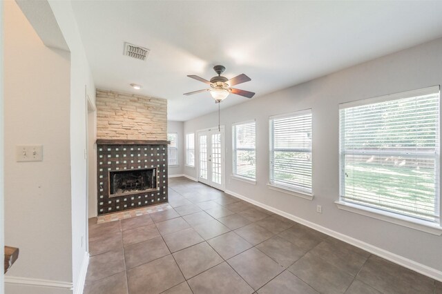 8726 San Fernando Way, Dallas, TX 75218 - unfurnished living room featuring a ceiling fan, a large fireplace, tile patterned floors, and baseboards