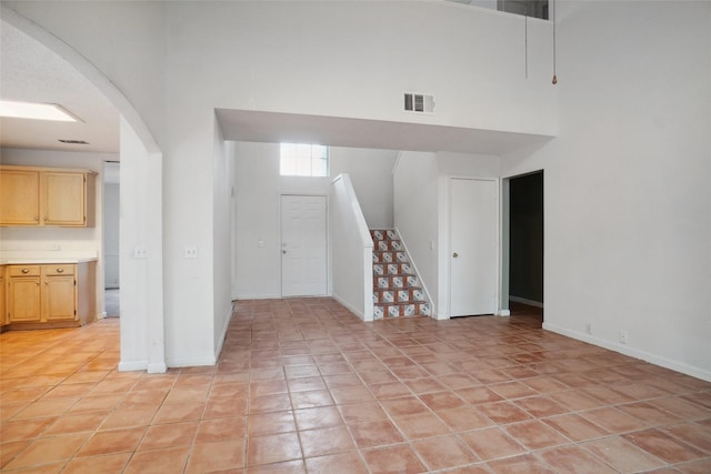 317 Stately Oak Ln, Lake Dallas, TX 75065 - empty room with a towering ceiling, stairway, arched walkways, and baseboards
