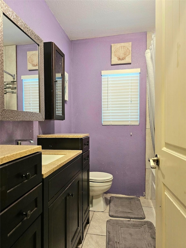 203 Hollywood St, Coleman, TX 76834 - bathroom featuring toilet, vanity, tile patterned floors, a shower with shower curtain, and a textured ceiling