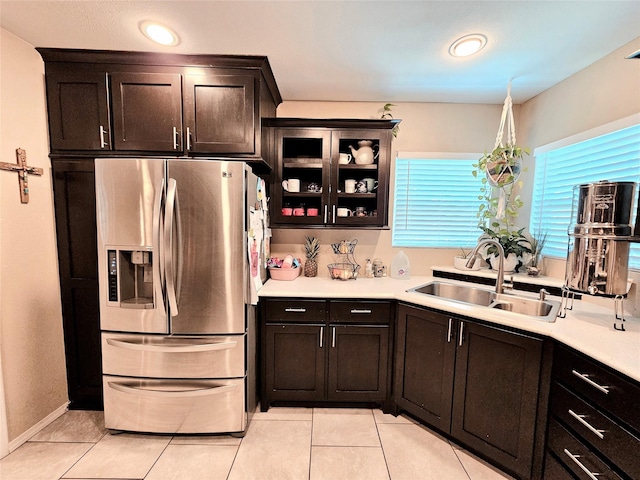 203 Hollywood St, Coleman, TX 76834 - kitchen with stainless steel fridge, a sink, light tile patterned floors, light countertops, and glass insert cabinets