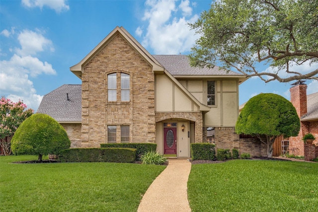 1541 Croston Dr, Plano, TX 75075 - view of front facade featuring stucco siding, a front lawn, brick siding, and roof with shingles