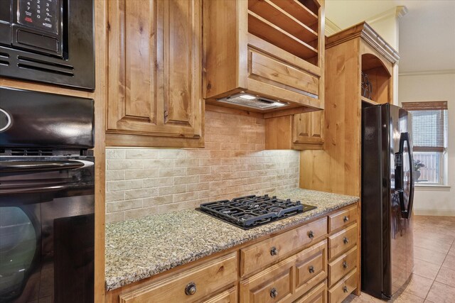 6708 Mustang Trl, Sanger, TX 76266 - kitchen featuring black appliances, decorative backsplash, light stone counters, light tile patterned floors, and crown molding