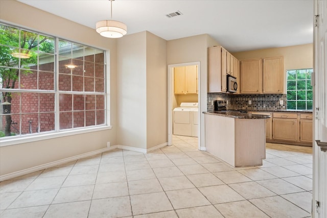 10120 Preston Vineyard Dr, Frisco, TX 75035 - kitchen with washer and dryer, range, stainless steel microwave, backsplash, and light brown cabinets