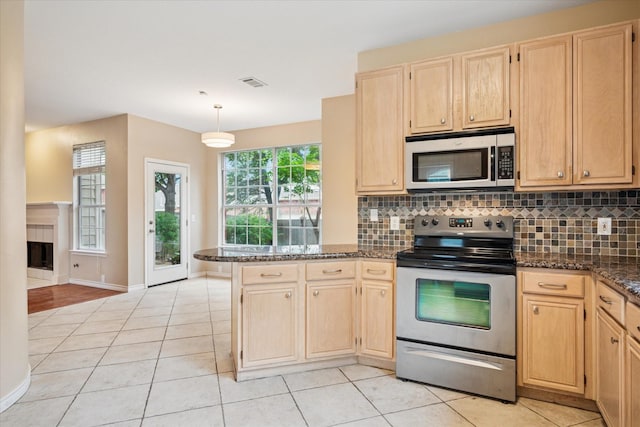 10120 Preston Vineyard Dr, Frisco, TX 75035 - kitchen featuring appliances with stainless steel finishes, light brown cabinetry, a peninsula, and light tile patterned floors