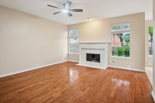 10120 Preston Vineyard Dr, Frisco, TX 75035 - unfurnished living room featuring wood finished floors, ceiling fan, a tiled fireplace, and baseboards