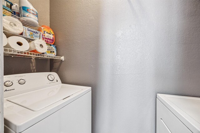 7340 Skillman St Unit 1207, Dallas, TX 75231 - laundry room featuring a textured wall and washing machine and dryer