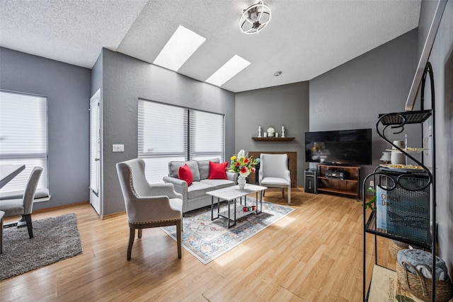 7340 Skillman St Unit 1207, Dallas, TX 75231 - living room with vaulted ceiling, a skylight, a textured ceiling, and wood finished floors