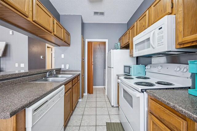 7340 Skillman St Unit 1207, Dallas, TX 75231 - kitchen featuring white appliances, dark countertops, a sink, brown cabinetry, and a textured ceiling