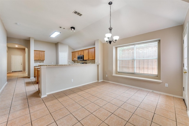 1117 Red Hawk Dr, Frisco, TX 75033 - kitchen with stainless steel microwave, lofted ceiling, arched walkways, light tile patterned flooring, and a peninsula