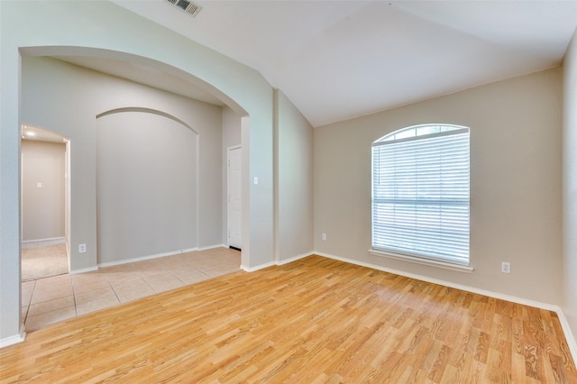1117 Red Hawk Dr, Frisco, TX 75033 - spare room featuring arched walkways, wood finished floors, baseboards, and lofted ceiling
