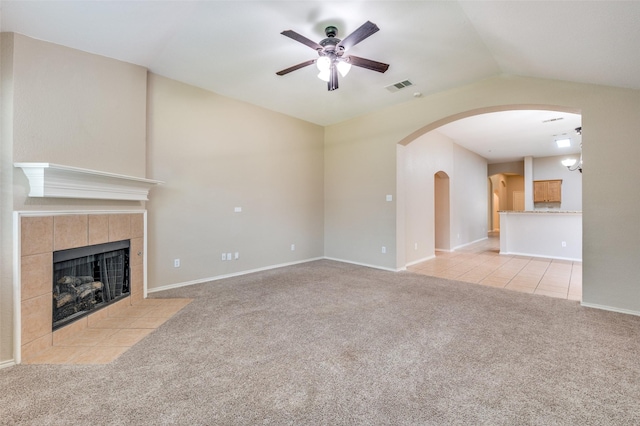 1117 Red Hawk Dr, Frisco, TX 75033 - unfurnished living room featuring vaulted ceiling, carpet, ceiling fan, arched walkways, and a tiled fireplace