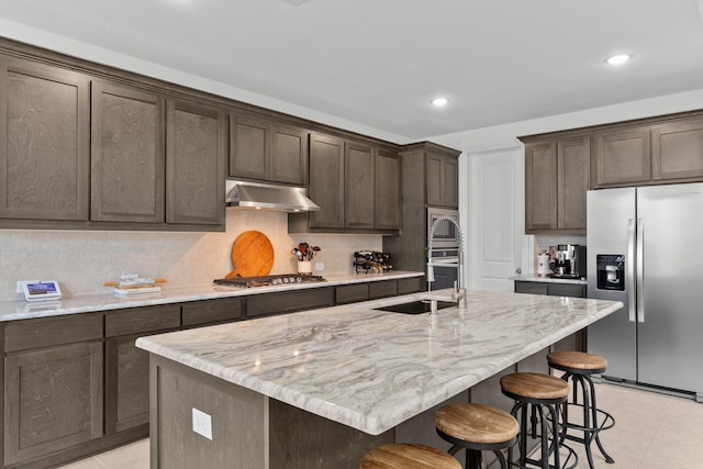 2788 Walker Way, Northlake, TX 76247 - kitchen featuring stainless steel appliances, a sink, under cabinet range hood, light tile patterned floors, and dark brown cabinets