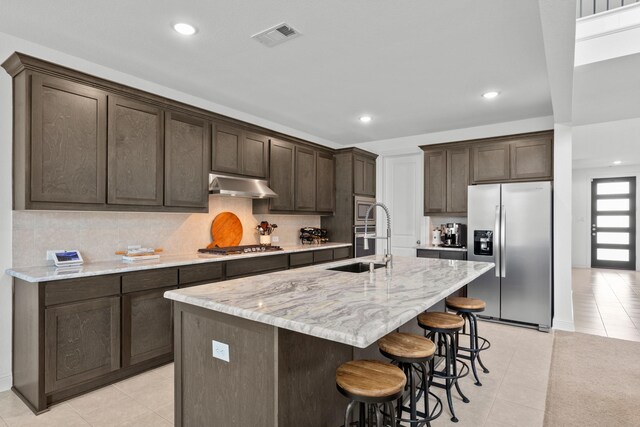 2788 Walker Way, Northlake, TX 76247 - kitchen featuring appliances with stainless steel finishes, under cabinet range hood, light tile patterned flooring, a sink, and dark brown cabinetry