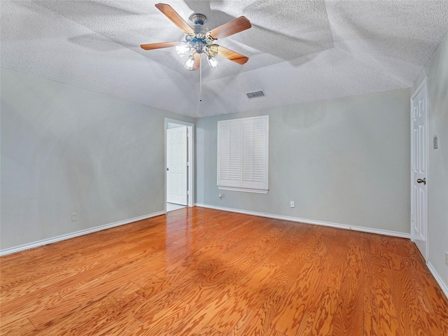 211 Indian Trace Ln, Waxahachie, TX 75165 - spare room featuring wood finished floors, a ceiling fan, a textured ceiling, vaulted ceiling, and baseboards