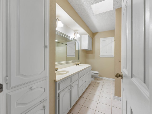 211 Indian Trace Ln, Waxahachie, TX 75165 - full bathroom featuring a skylight, baseboards, double vanity, a textured ceiling, and tile patterned floors