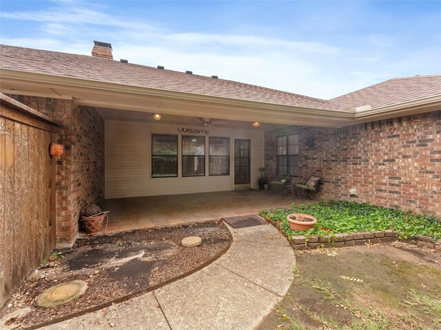 211 Indian Trace Ln, Waxahachie, TX 75165 - doorway to property with a patio area, a chimney, roof with shingles, and brick siding