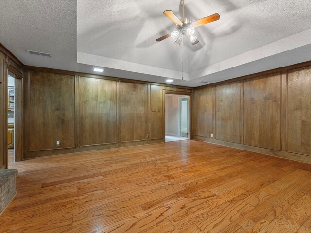 211 Indian Trace Ln, Waxahachie, TX 75165 - spare room with a textured ceiling, light wood-style floors, a ceiling fan, and wood walls