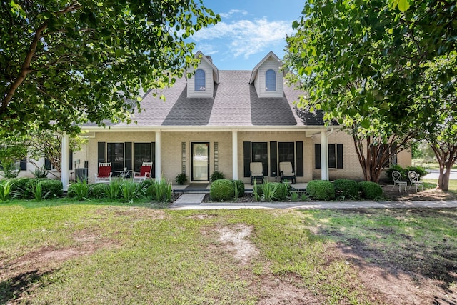 424 Kincannon Ln, Rhome, TX 76078 - cape cod-style house featuring a porch, brick siding, a front yard, and a shingled roof