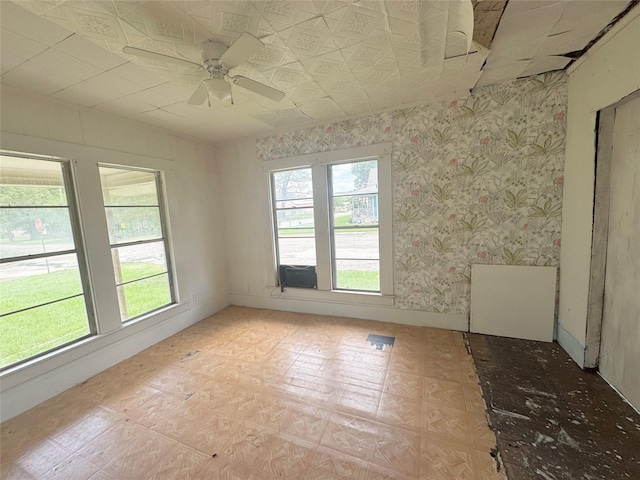 601 Elm St, Teague, TX 75860 - empty room featuring a ceiling fan, cooling unit, and wallpapered walls