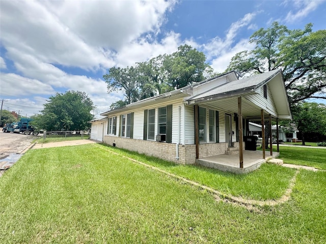 601 Elm St, Teague, TX 75860 - view of property exterior with a lawn, concrete driveway, a patio area, brick siding, and an attached garage