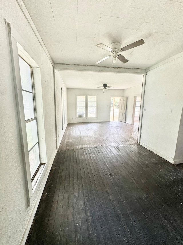 601 Elm St, Teague, TX 75860 - unfurnished living room with wood-type flooring, ceiling fan, and baseboards