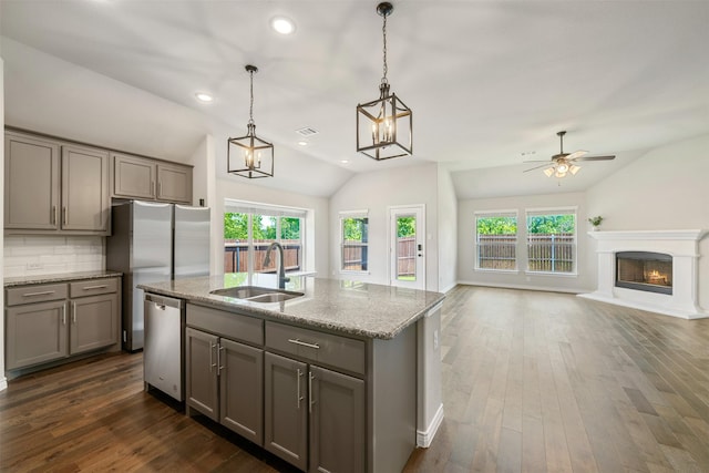 2627 Askern Ct, Grand Prairie, TX 75052 - kitchen with appliances with stainless steel finishes, gray cabinets, vaulted ceiling, a sink, and recessed lighting