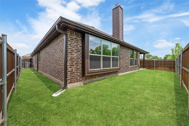 2627 Askern Ct, Grand Prairie, TX 75052 - rear view of house with brick siding, a chimney, and central AC