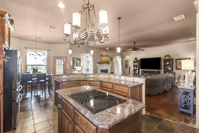 217 Silver Rose Blvd, Burleson, TX 76028 - kitchen with freestanding refrigerator, a chandelier, black electric cooktop, a spacious island, and brown cabinets
